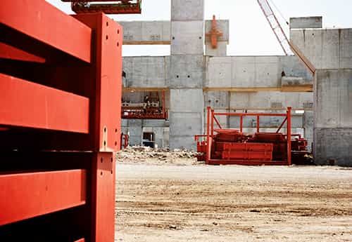 a commercial construction site with concrete walls and temporary trash bins